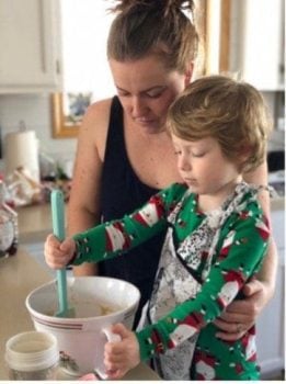 teacher helping child learn to cook